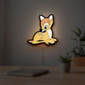 Bambi LED lightbox hanging on a room wall with soft yellow light