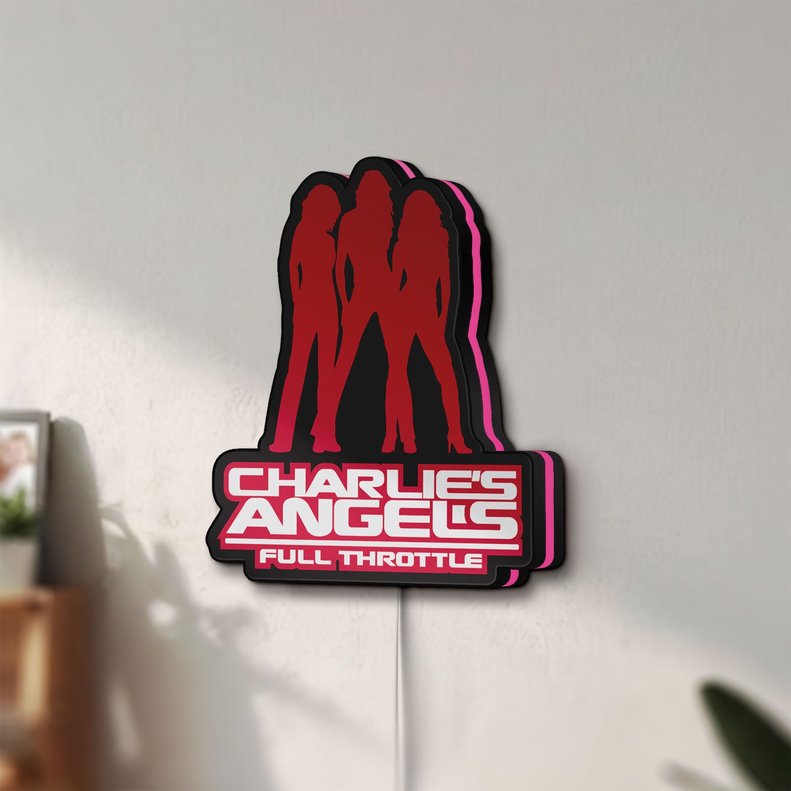 Unlit Charlie's Angels LED lightbox mounted on a wall in daylight