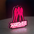Charlie's Angels LED lightbox standing on a desk from an angled side view with pink glow