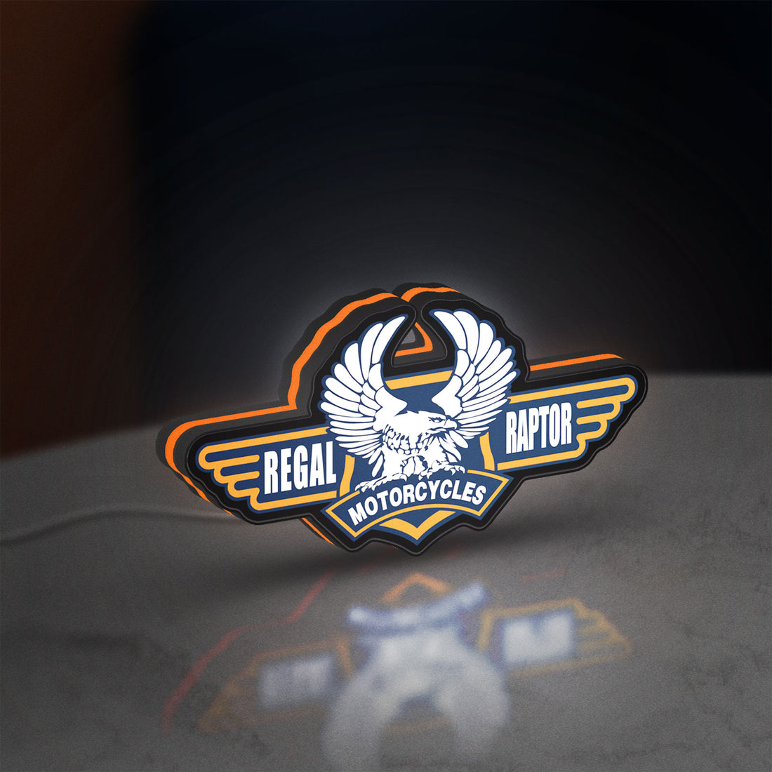 Regal Raptor Motorcycles LED lightbox hanging on a wall with orange glow