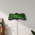 Unlit Green Lantern LED lightbox mounted on a wall in daylight