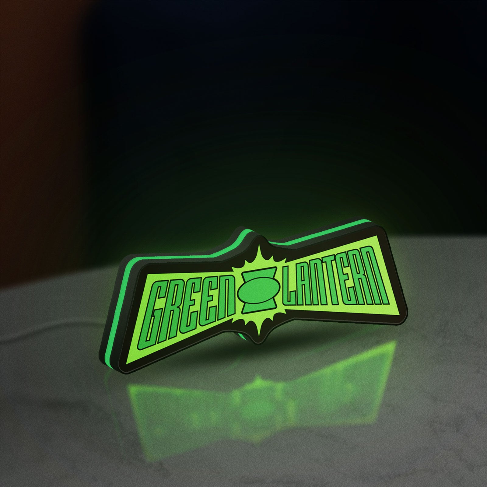 Green Lantern LED lightbox standing on a desk from an angled side view with green glow