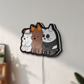 Unlit We Bare Bears LED lightbox mounted on a wall in daylight