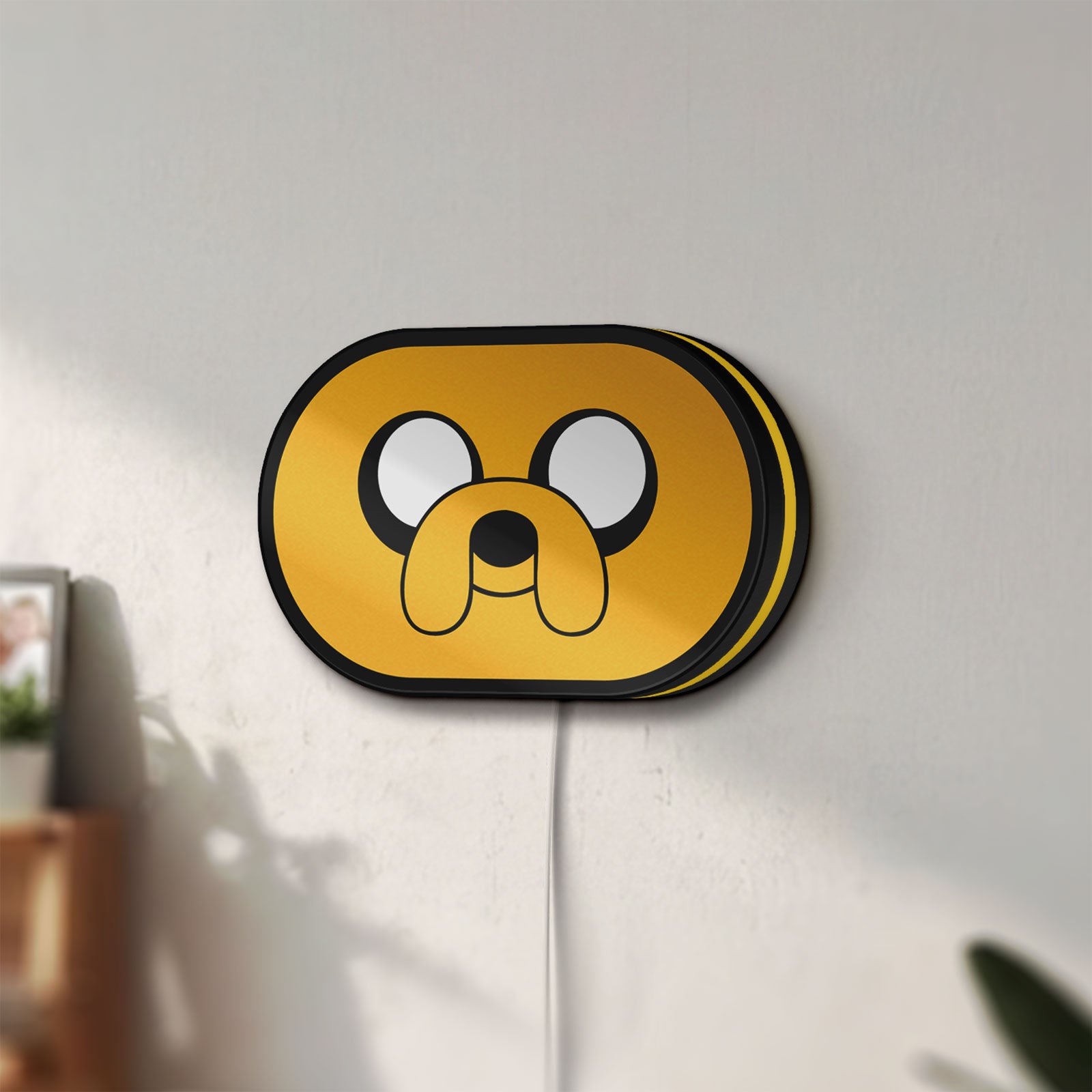 Unlit Adventure Time Jake LED lightbox mounted on a wall in daylight