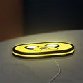 Adventure Time Jake LED lightbox lying flat on a desk with yellow glow