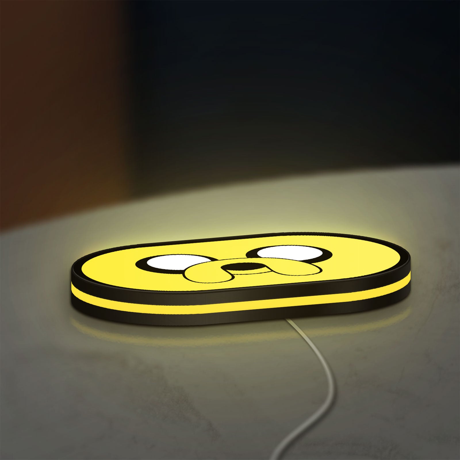 Adventure Time Jake LED lightbox lying flat on a desk with yellow glow
