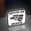 Hecho en Mexico LED lightbox standing on a desk from an angled side view with white glow