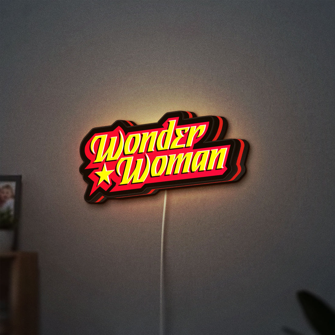 Wonder Woman LED lightbox hanging on a wall with red glow