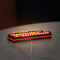 Wonder Woman LED lightbox lying flat on a desk with red glow