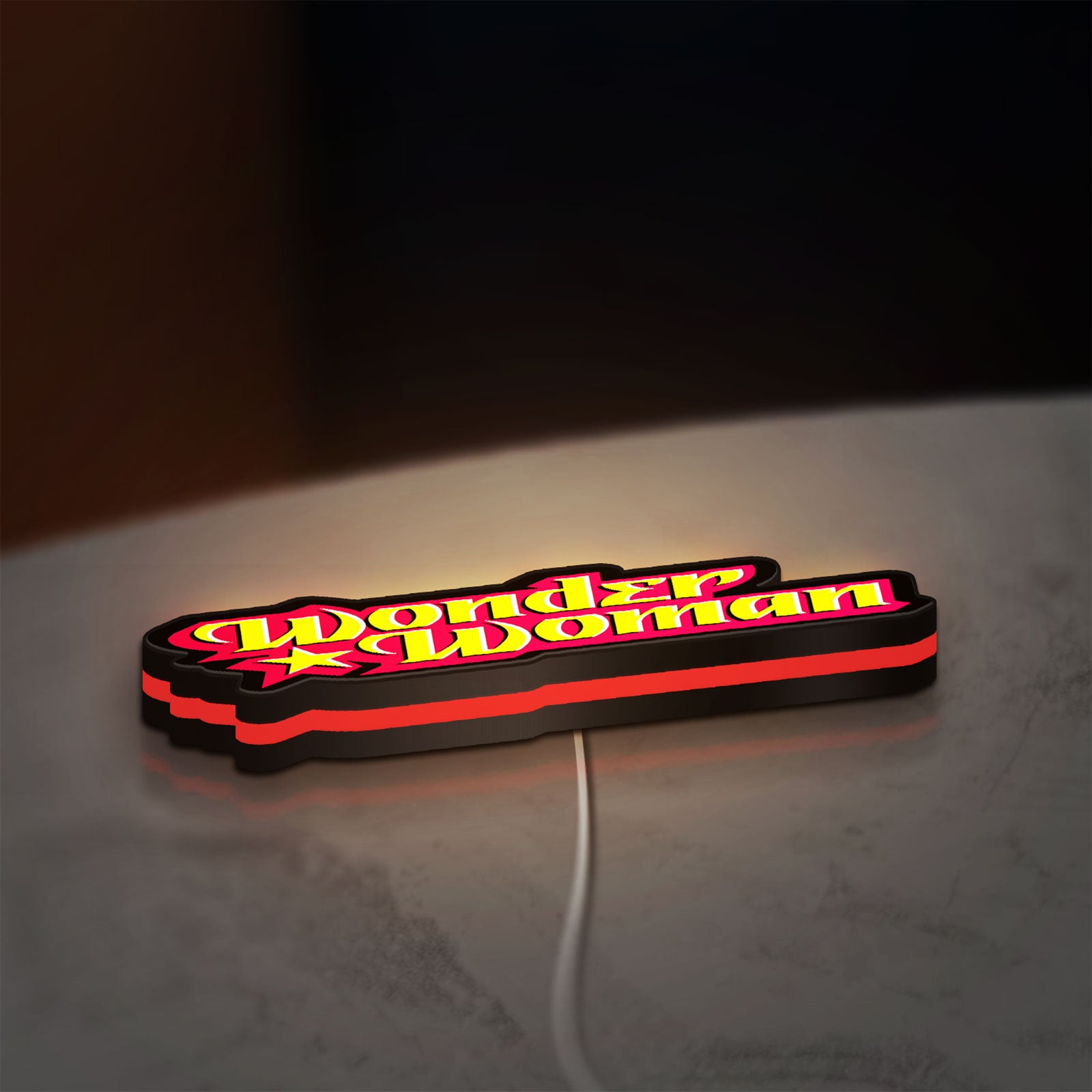 Wonder Woman LED lightbox lying flat on a desk with red glow