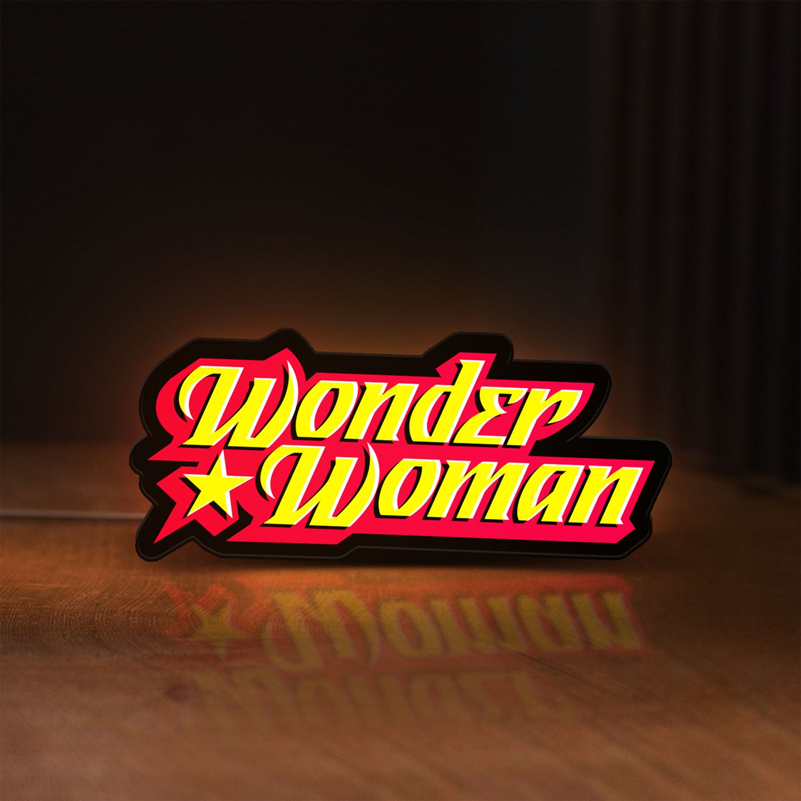 Front view of Wonder Woman LED lightbox sign glowing on a wooden desk