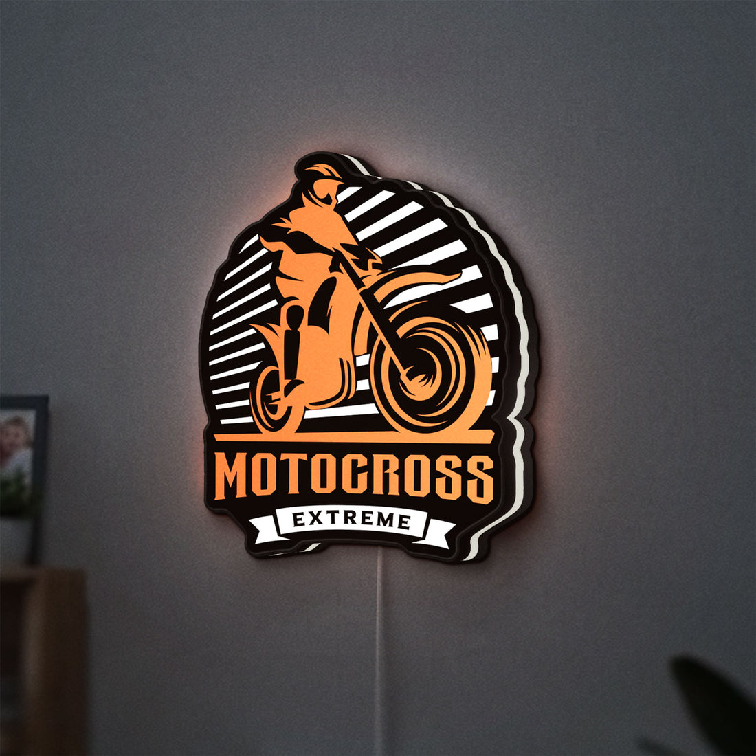 Motocross LED lightbox hanging on a wall with white glow