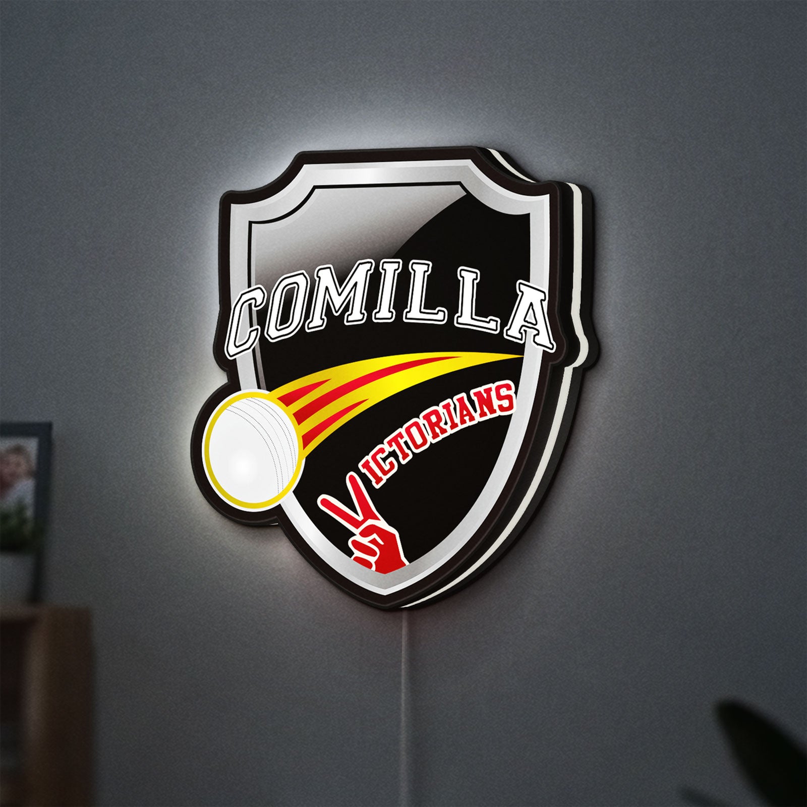Comilla Victorians LED lightbox hanging on a wall with white glow
