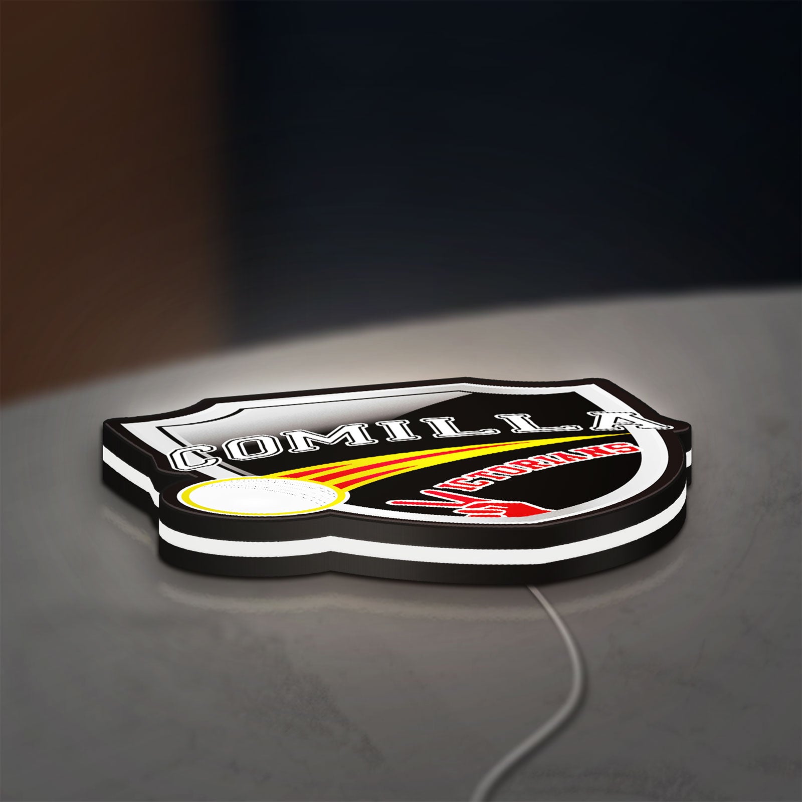 Comilla Victorians LED lightbox lying flat on a desk with white glow