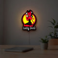 Lucky Devil LED lightbox hanging on a room wall with soft red light