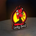 Lucky Devil LED lightbox standing on a desk from an angled side view with red glow