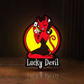 Front view of Lucky Devil LED lightbox sign glowing on a wooden desk