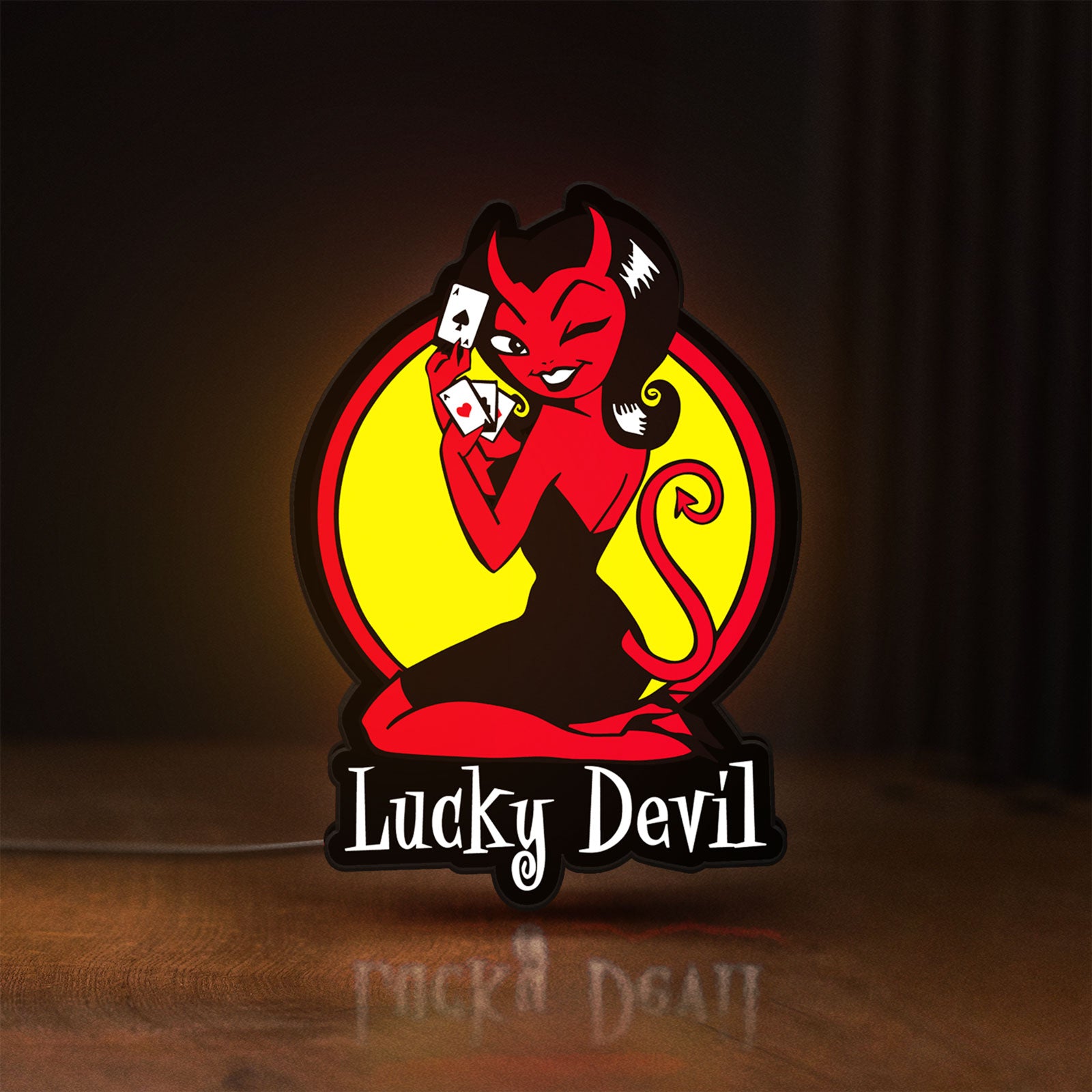 Front view of Lucky Devil LED lightbox sign glowing on a wooden desk