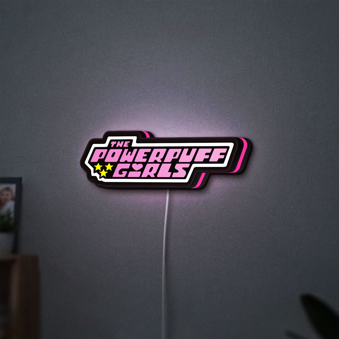 Power Puff Girls LED lightbox hanging on a wall with pink glow