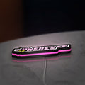 Power Puff Girls LED lightbox lying flat on a desk with pink glow