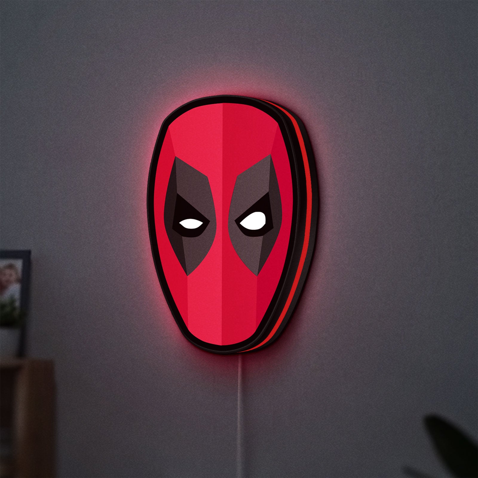 Deadpool Head LED lightbox hanging on a wall with red glow