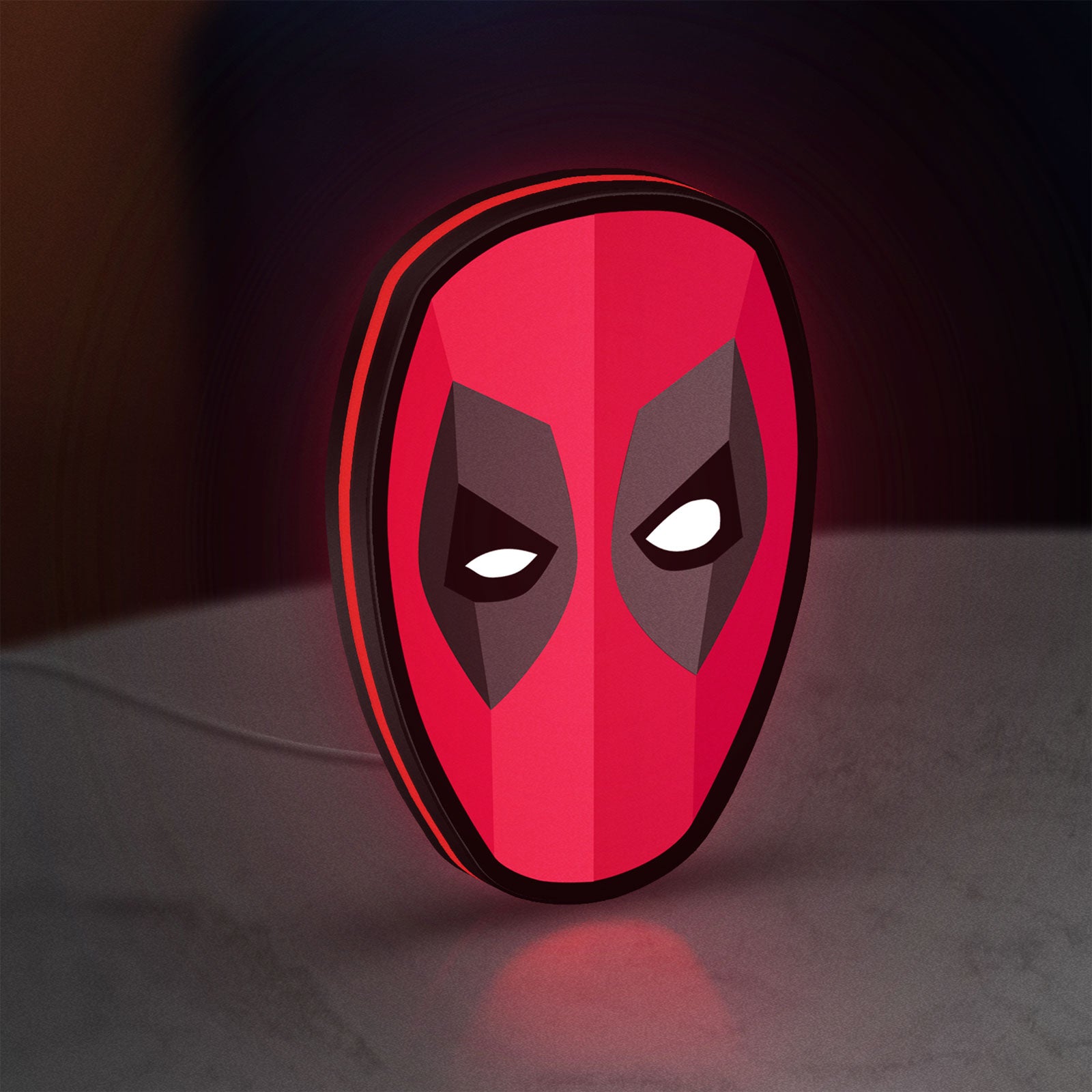 Deadpool Head LED lightbox standing on a desk from an angled side view with red glow