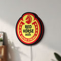 Unlit Red Horse Beer LED lightbox mounted on a wall in daylight