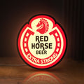 Front view of Red Horse Beer LED lightbox sign glowing on a wooden desk