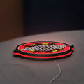 Gang Starr LED lightbox lying flat on a desk with red glow