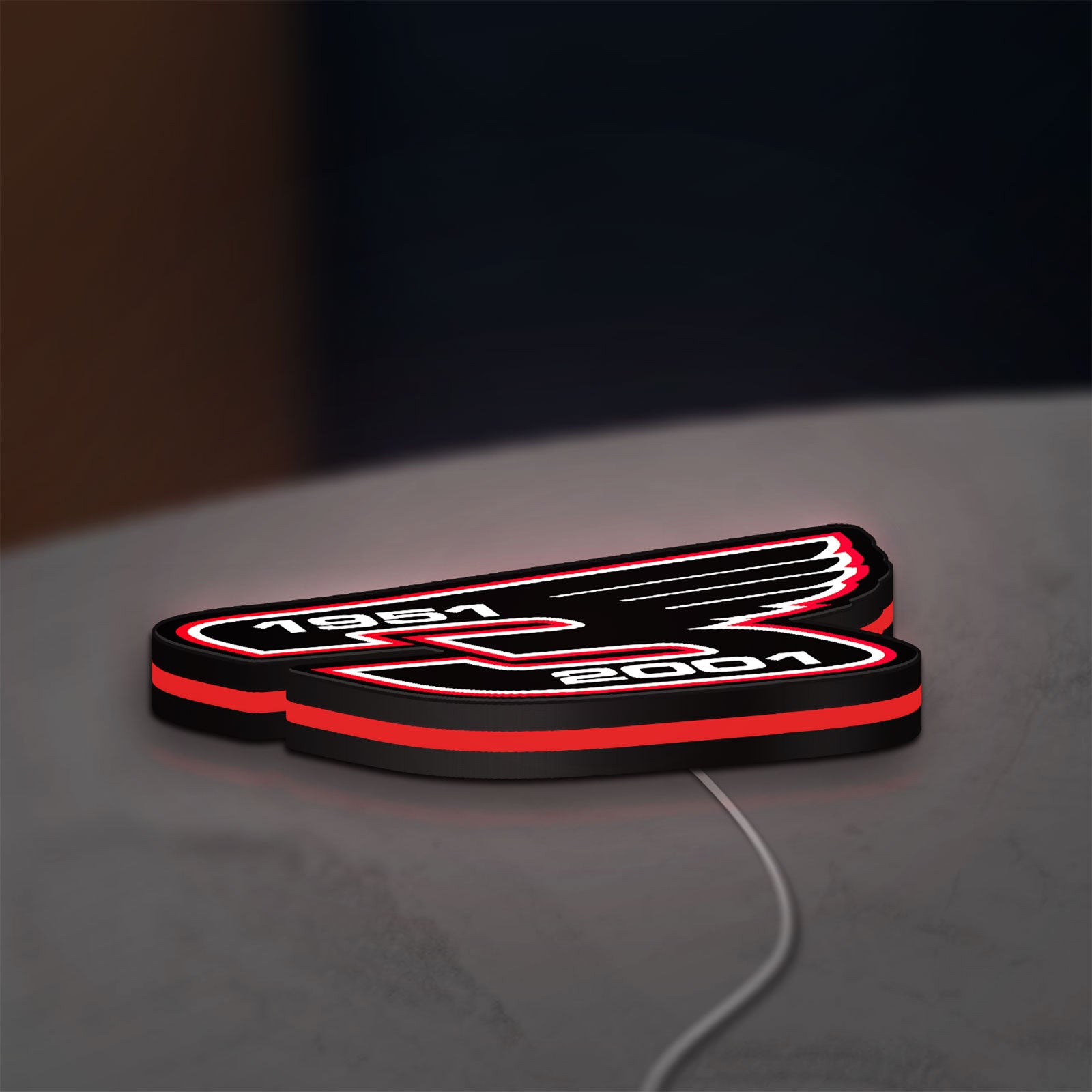 Dale Earnhardt Wings LED lightbox lying flat on a desk with red glow