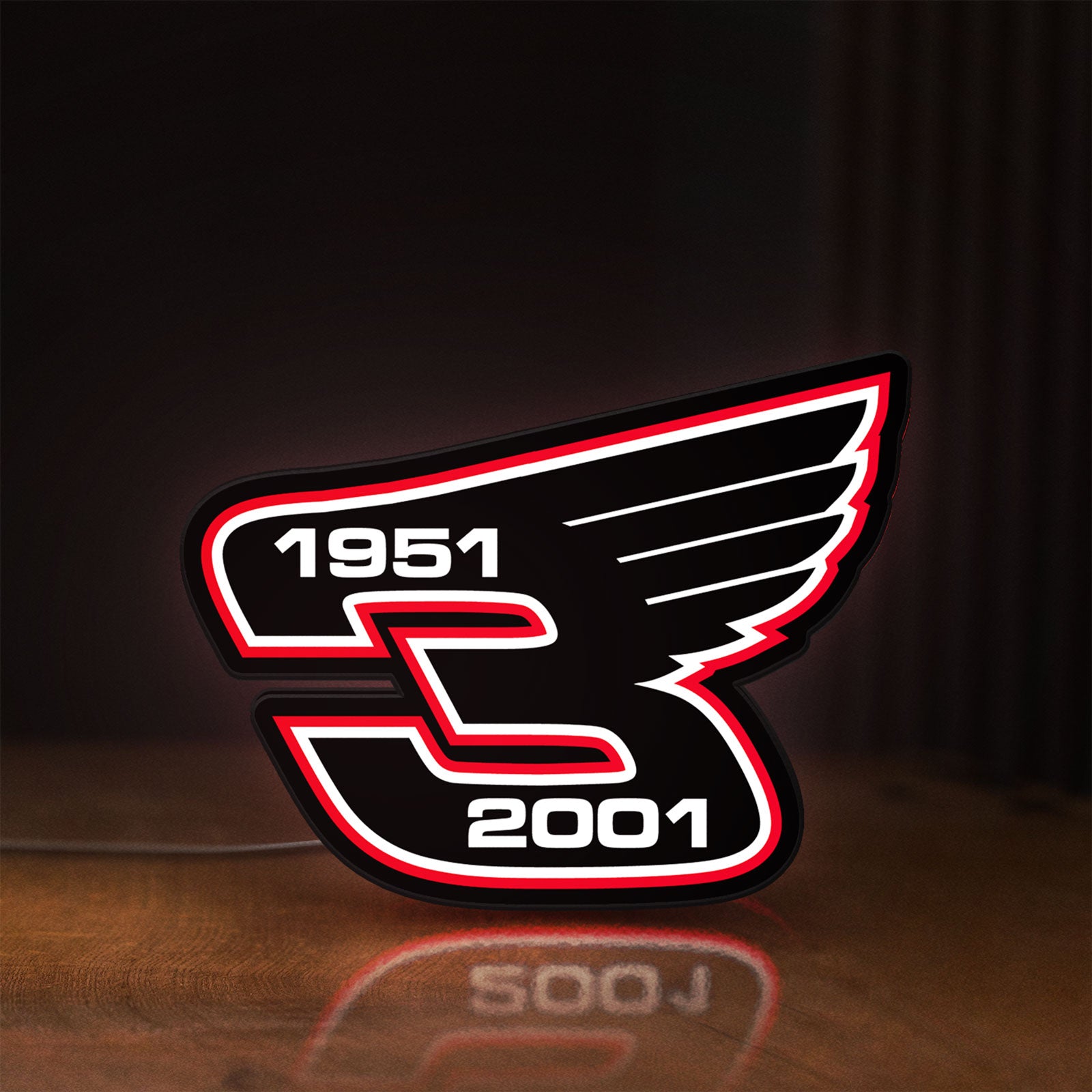 Front view of Dale Earnhardt Wings LED lightbox sign glowing on a wooden desk