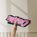 Unlit Hatsune Miku LED lightbox held by hand to show size and details