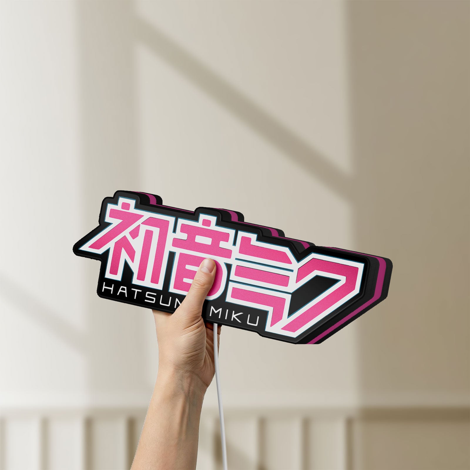 Unlit Hatsune Miku LED lightbox held by hand to show size and details