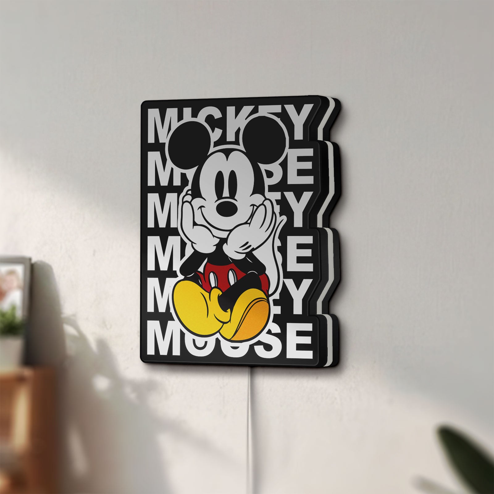 Unlit Mickey Mouse LED lightbox mounted on a wall in daylight