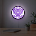 Dodgeball Globo Gym Purple Cobras LED lightbox hanging on a room wall with soft purple light