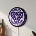 Unlit Dodgeball Globo Gym Purple Cobras LED lightbox mounted on a wall in daylight