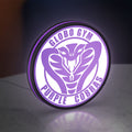Dodgeball Globo Gym Purple Cobras LED lightbox standing on a desk from an angled side view with purple glow