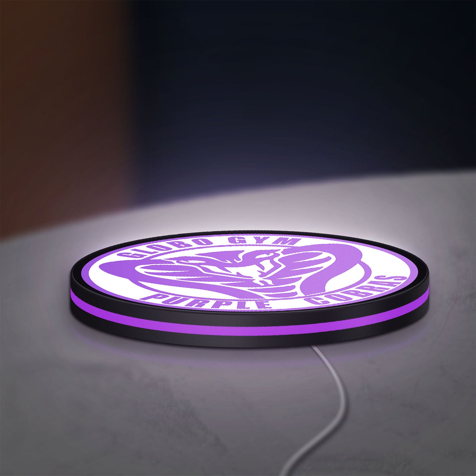 Dodgeball Globo Gym Purple Cobras LED lightbox lying flat on a desk with purple glow