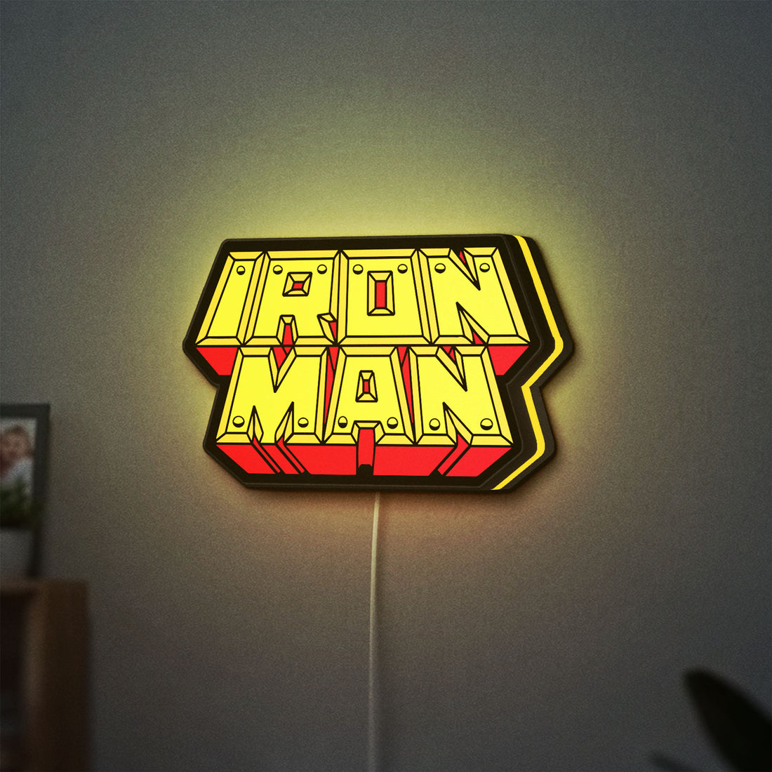 Iron Man LED lightbox hanging on a wall with yellow glow