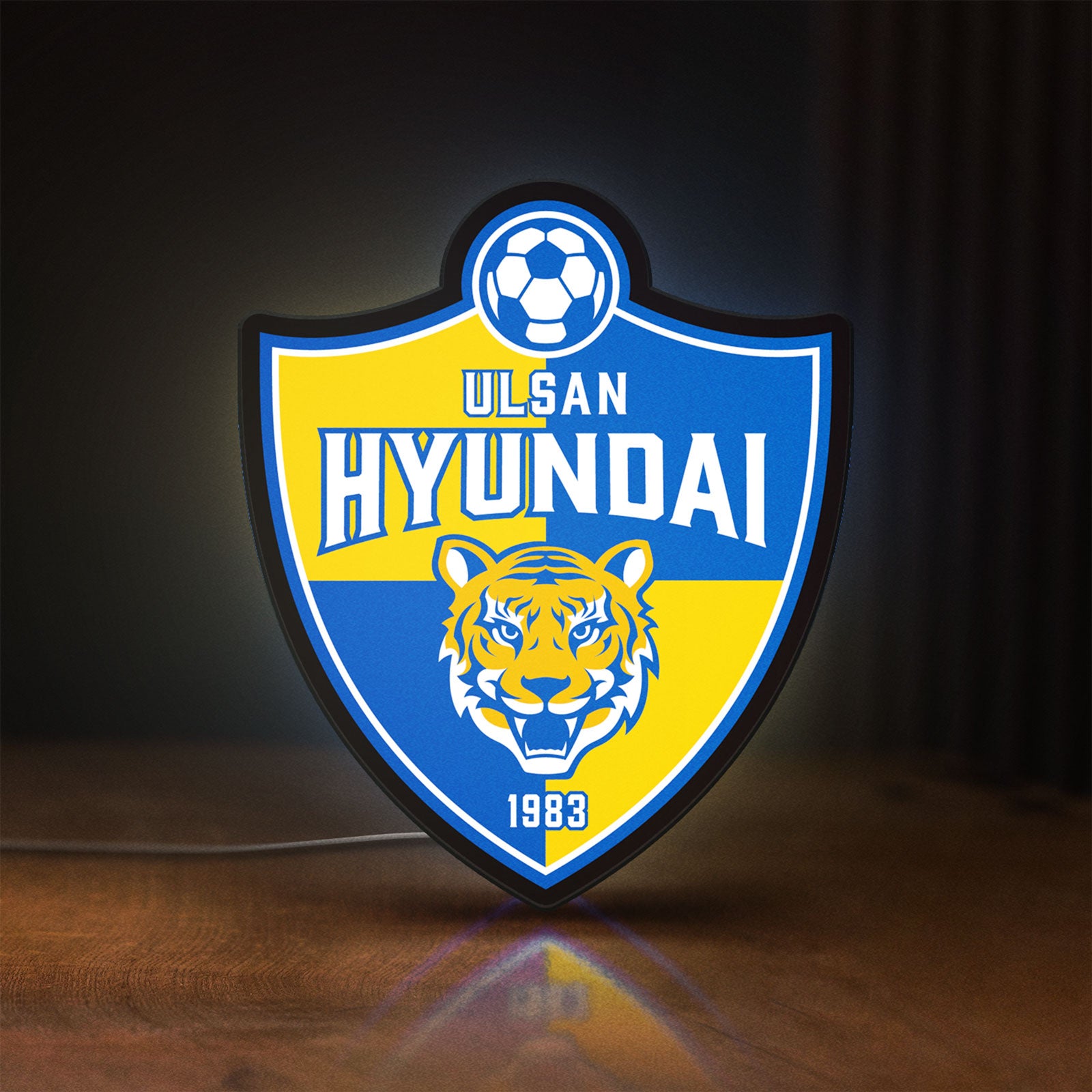 Front view of K-League Ulsan Hyundai LED lightbox sign glowing on a wooden desk