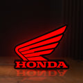 Front view of Honda LED lightbox sign glowing on a wooden desk
