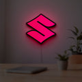 Suzuki LED lightbox hanging on a room wall with soft red light