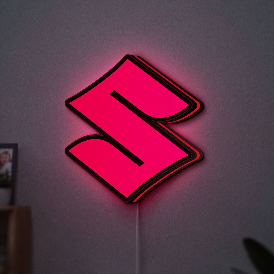 Suzuki LED lightbox hanging on a wall with red glow