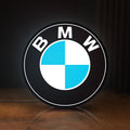 Front view of BMW LED lightbox sign glowing on a wooden desk