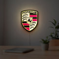 Porsche LED lightbox hanging on a room wall with soft yellow light