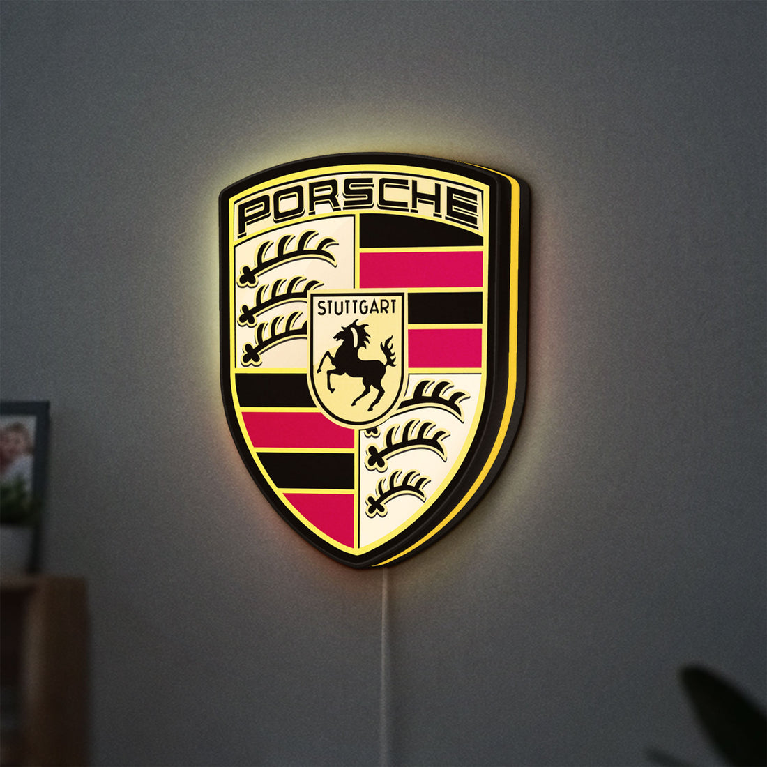 Porsche LED lightbox hanging on a wall with yellow glow