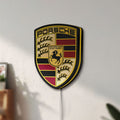 Unlit Porsche LED lightbox mounted on a wall in daylight