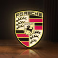 Front view of Porsche LED lightbox sign glowing on a wooden desk