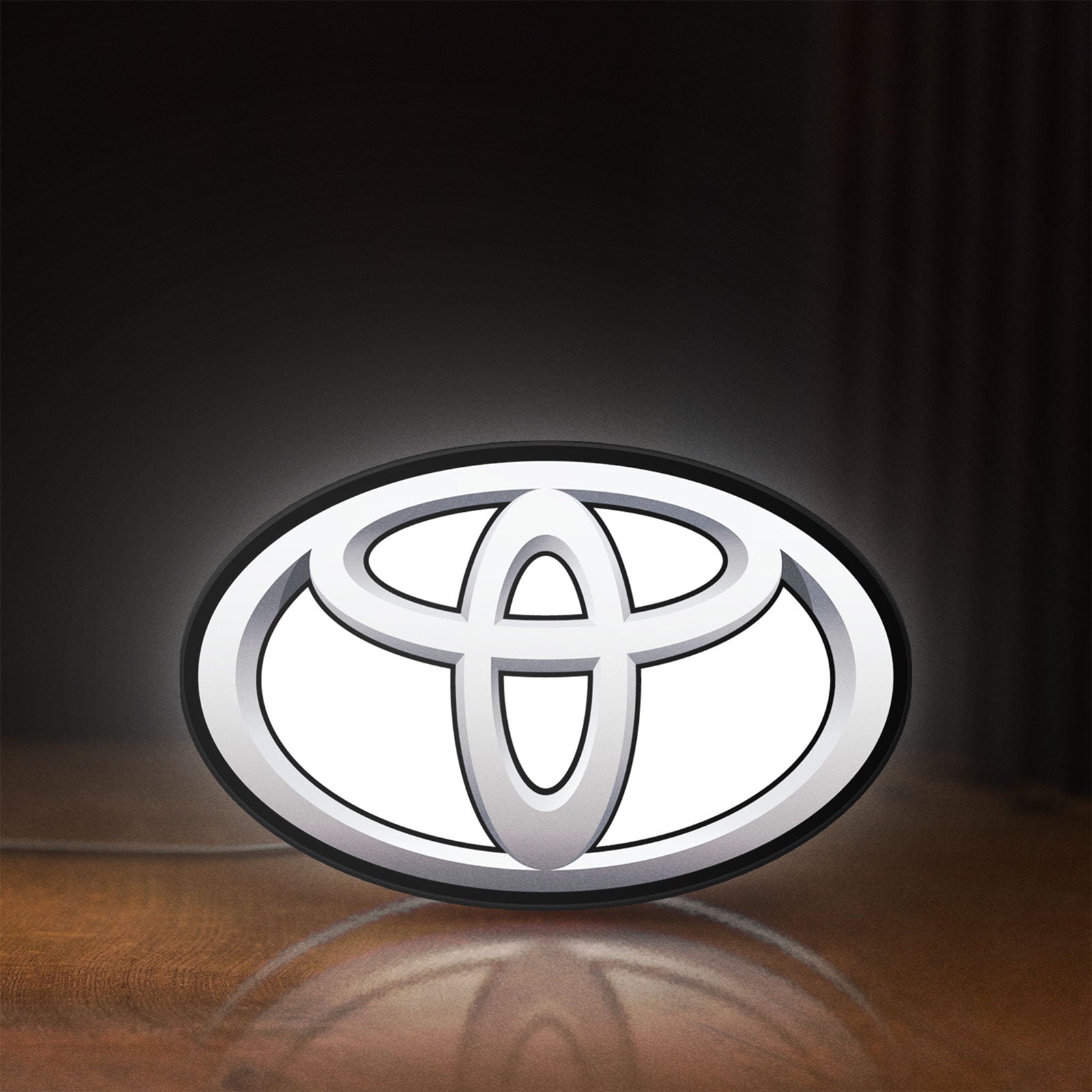 Front view of Toyota LED lightbox sign glowing on a wooden desk