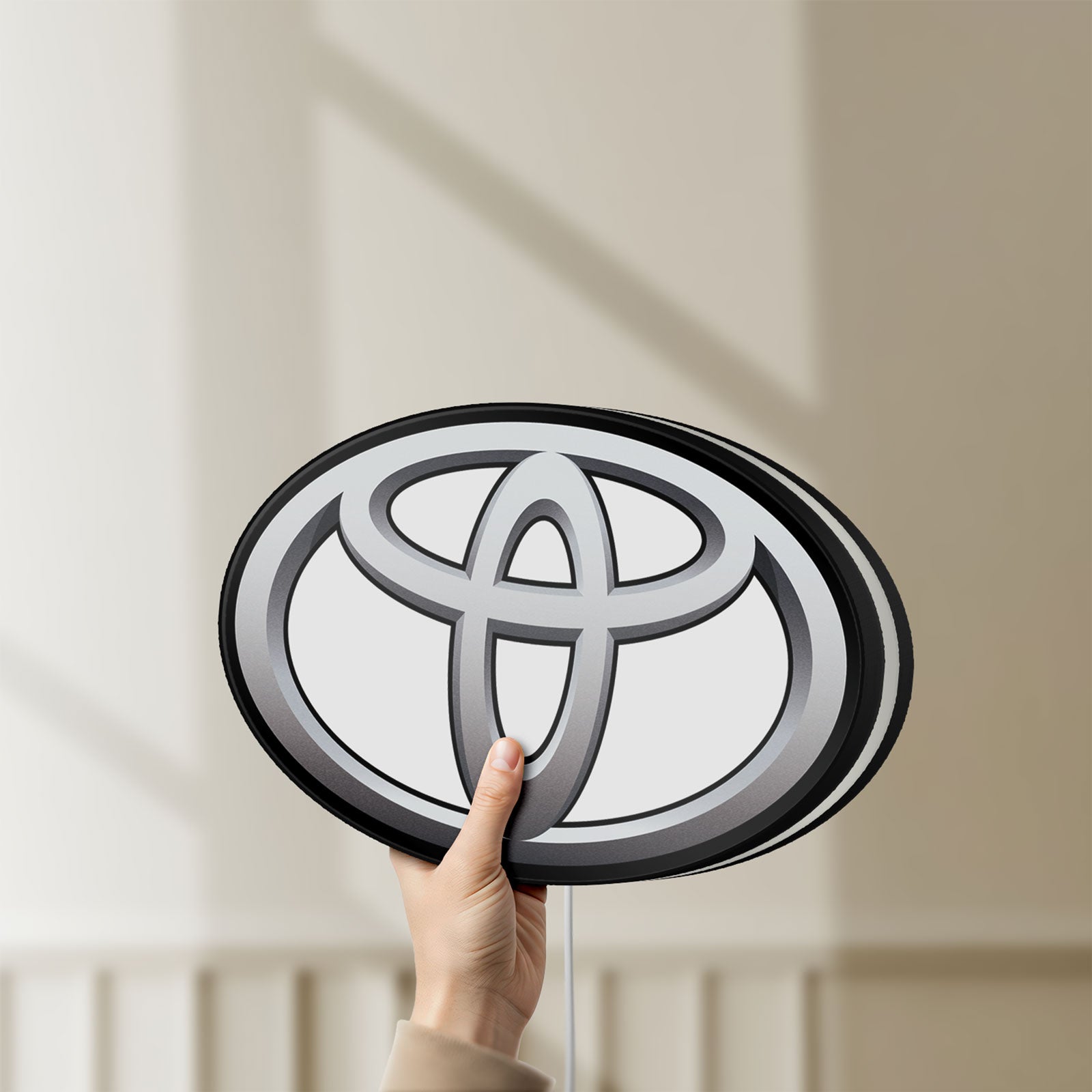 Unlit Toyota LED lightbox held by hand to show size and details